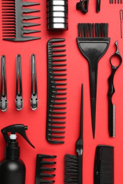 Kırmızı arka planda farklı kuaför aletleri, düz yatıyordu