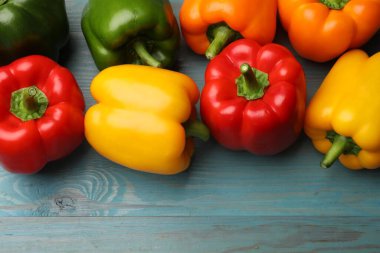 Taze renkli dolmalık biberler mavi ahşap masada, düz yatıyordu.