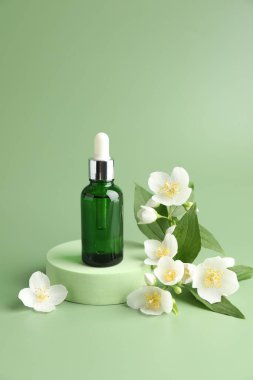 Yeşil arka planda kozmetik ürünleri ve yasemin çiçekleri