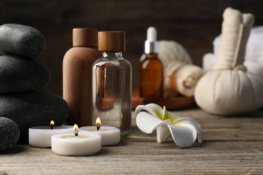 Kozmetik ürünleri ve spa taşlarıyla ahşap masaya yakın plan kompozisyon.