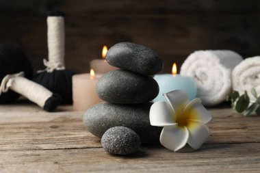 Tahta masanın üzerinde spa taşları olan kompozisyon, yakın plan.