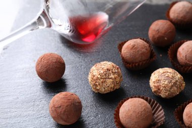 Lezzetli yer mantarı bonbonları ve arta kalan kırmızı şarap koyu dokulu masada, yakın plan.