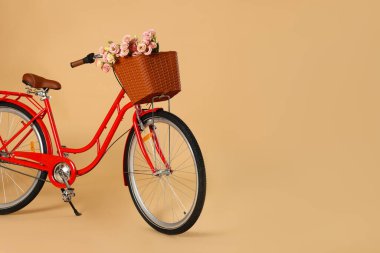 Soluk turuncu arka planda bir sepet güzel çiçekli bisiklet. Metin için boşluk