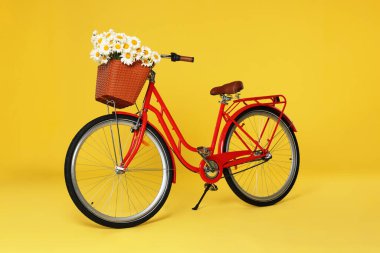 Sarı arka planda güzel çiçekli bisiklet sepeti