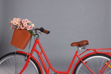 Gri arka planda bir sepet güzel çiçekli bisiklet.
