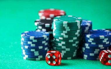 Kumarhane fişleri ve zarları yeşil masada, yakın plan.