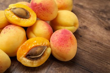 Ahşap masada bir sürü taze kayısı, yakın plan.