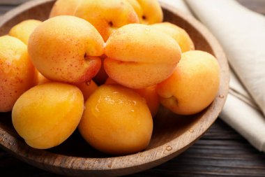 Tahta masadaki kasede taze kayısılar, yakın plan.