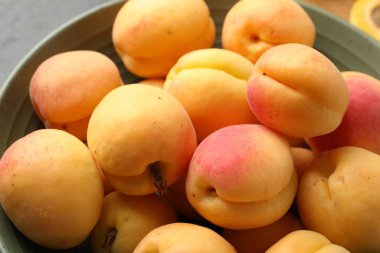 Bir sürü taze kayısı kasede, yakın plan.