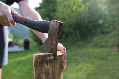 Yakacak odunları balta ile kesen adam, yakın plan.