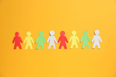 Turuncu arka planda, düzlükte birçok insan kağıt figürü