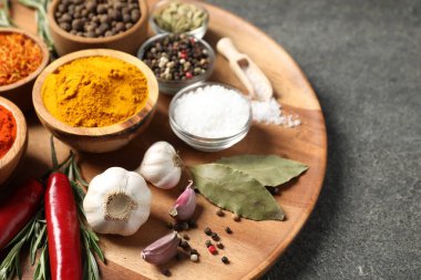 Gri masada farklı aromatik baharatlar, yakın plan.