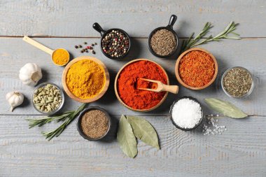 Gri ahşap masada farklı aromatik baharatlar var.