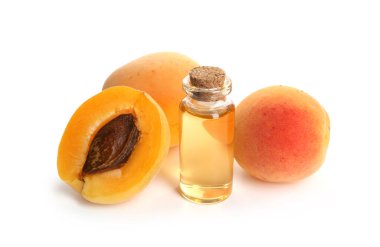 Bir şişe gerekli yağ ve beyaz üzerine izole edilmiş taze kayısılar.