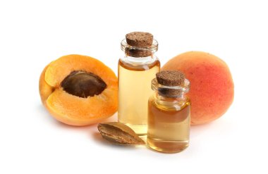 Beyaz üzerine izole edilmiş yağ, taze kayısı ve çekirdek şişeleri.