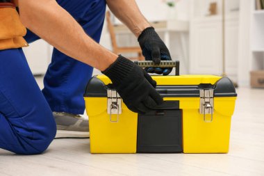 Kapalı mekanda alet çantası olan profesyonel bir tamirci.