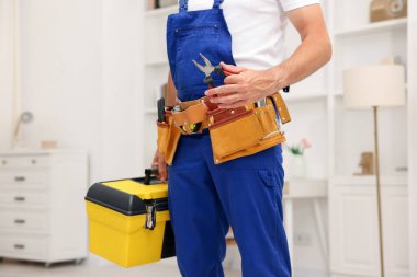 Kapalı mekanda alet çantası olan profesyonel bir tamirci.