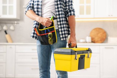 Kapalı mekanda alet çantası olan profesyonel bir tamirci.