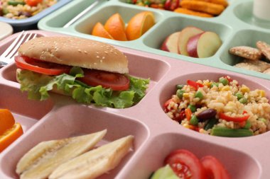 Masada lezzetli yiyecekler olan plastik tepsiler, yakın çekim. Okul yemeği.