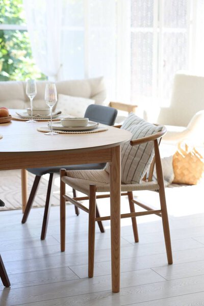 Beautiful table setting, chairs and decor in dining room. Interior design