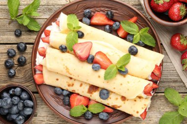 Böğürtlenli krep, krema ve nane, ahşap masa, düz uzanma