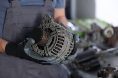 Otomobil parçaları. Alternatörü kapalı mekanda olan profesyonel bir tamirci, yakın plan. Metin için boşluk