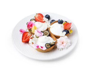 Lezzetli tatlı. Kremalı tart, böğürtlen ve çiçeklerle bembeyaz