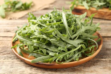 Taze yeşil roka yaprakları ahşap masada, yakın plan.