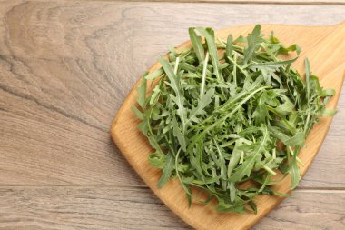 Taze yeşil roka yaprakları ahşap masanın üstünde, üst tarafta. Metin için boşluk