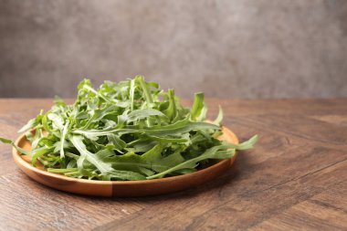 Taze yeşil roka yaprakları ahşap masada, yakın plan. Metin için boşluk