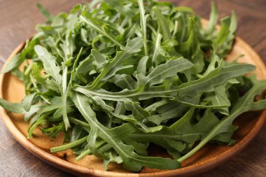 Taze yeşil roka yaprakları ahşap masada, yakın plan.