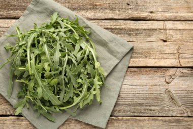 Taze yeşil roka yaprakları ahşap masanın üstünde, üst tarafta. Metin için boşluk