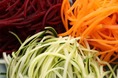 Arka plan olarak farklı sebze erişteleri, yakın plan. Vejetaryen yemeği.