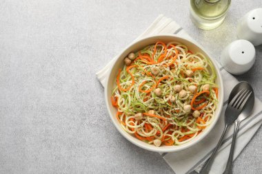 Vejetaryen yemeği. Gri masada servis edilen nohutlu lezzetli sebzeli erişte. Metin için boşluk