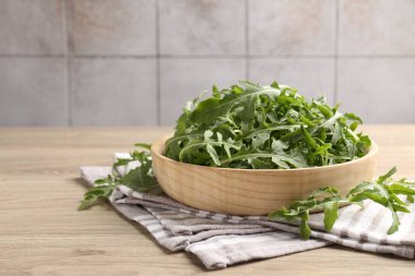 Taze yeşil roka yaprakları açık ahşap masada, yakın plan. Metin için boşluk