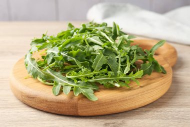 Taze yeşil roka yaprakları açık ahşap masada, yakın plan.