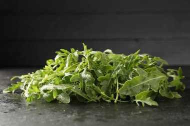 Taze yeşil roka yaprakları siyah masada, yakın plan.