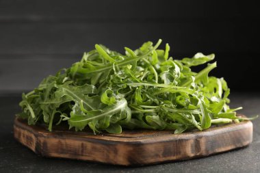 Taze yeşil roka yaprakları siyah masada, yakın plan.