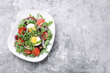 Lezzetli salata roka, sebze, yumurta ve tohumlar gri masada, üst manzara. Metin için boşluk