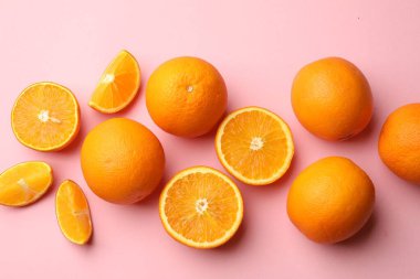 Pembe arka planda taze olgun portakallar, düz uzanmış.