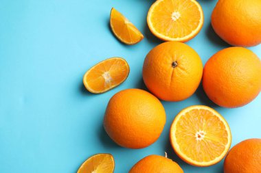 Açık mavi arka planda taze olgun portakallar, düz uzanmış. Metin için boşluk