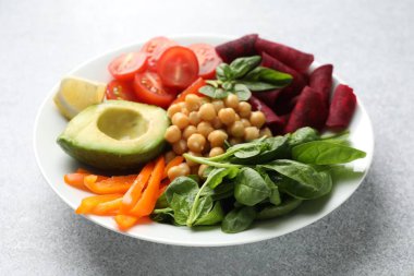 Açık gri masada farklı sağlıklı vejetaryen yemekleri, yakın plan.