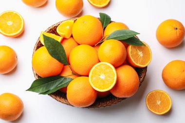 Taze taze portakallar ve beyaz arka planda yeşil yapraklar.