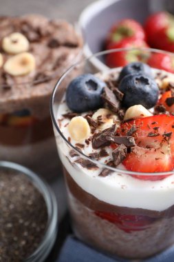 Chia tohumlu, fındıklı ve meyveli lezzetli çikolatalı pudingler masada, yakın plan.