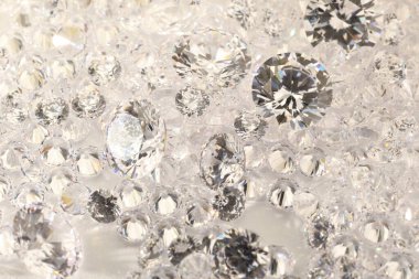 Işıklı arka planda pek çok parlak elmas, yakın plan