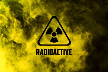 Radyoaktif işaret ve siyah arka planda sarı zehirli duman