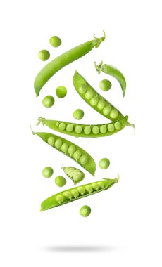 Beyaz arkaplana düşen yeşil bezelyeler ve kabuklar