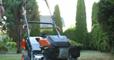 Lviv, Ukrayna - 2 Temmuz 2025: Dnipro-m çim biçme makinesinin marş ipini çeken ve bahçedeki yeşil çimleri kesen adam, yakın plan