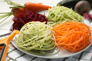 Farklı sebzeli şehriyeler, taze sebzeler ve masa soyucu, yakın plan. Vejetaryen yemeği.
