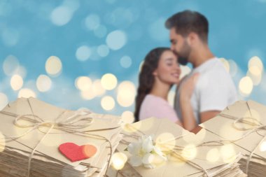 Romantik genç çift ve aşk mektupları, bokeh etkisi. Açık mavi arka planda sarılan kadın ve erkek